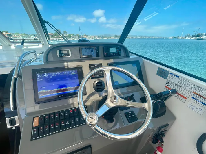 Hobi One Yacht Photos Pics Helm of 2015 Pursuit 345 Offshore boat with navigation screens and steering wheel.