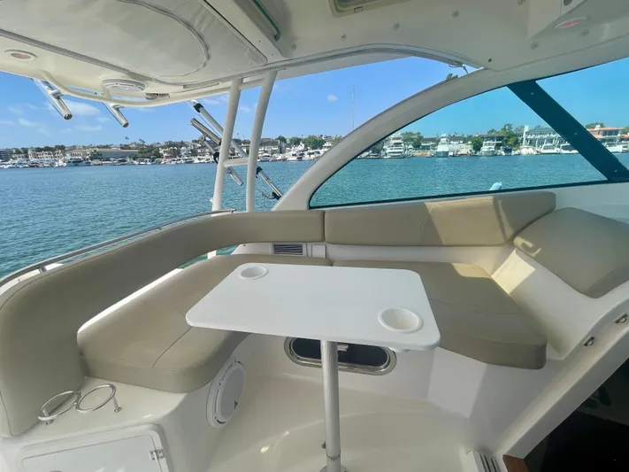Hobi One Yacht Photos Pics 2015 Pursuit 345 Offshore boat interior with seating and table, overlooking marina.