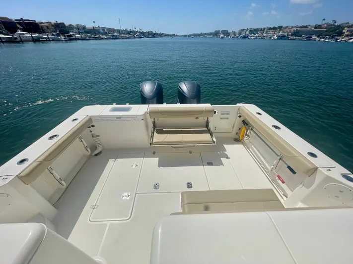 Hobi One Yacht Photos Pics 2015 Pursuit 345 Offshore boat deck with twin engines, overlooking calm waters.