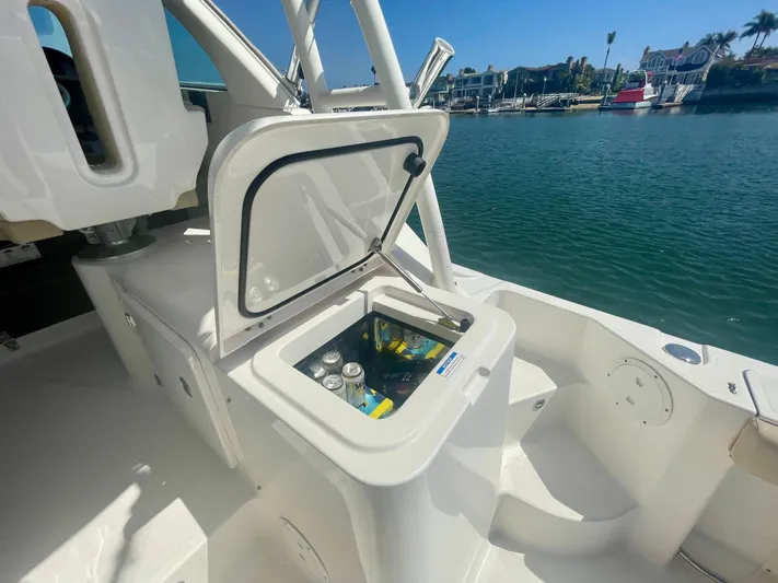 Hobi One Yacht Photos Pics 2015 Pursuit 345 Offshore boat with open cooler, docked by the water.