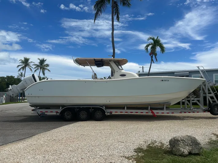  Yacht Photos Pics 2009 Mamba 350 boat on trailer, parked outdoors with palm trees and blue sky.