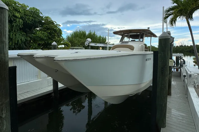  Yacht Photos Pics 2009 Mamba 350 boat docked near tropical trees and calm water.