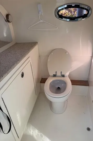  Yacht Photos Pics Compact bathroom in 2009 Mamba 350 boat with toilet, countertop, and porthole window.