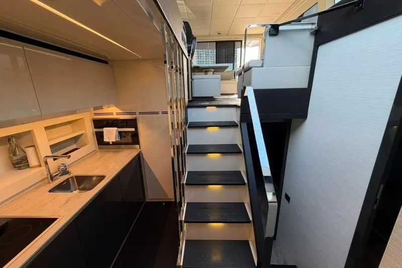  Yacht Photos Pics Luxurious interior of 2015 Pershing 70 yacht featuring modern kitchen and sleek staircase.