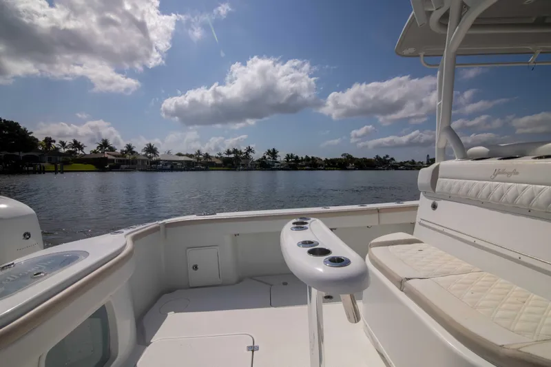 Kat Man Du Yacht Photos Pics 2017 Yellowfin 39 Center Console boat interior with seating and rod holders, overlooking a serene waterfront.