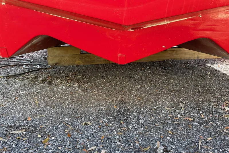 Asi Tender Yacht Photos Pics Red 1987 Commercial Buoy Tender hull resting on wooden supports, gravel ground.