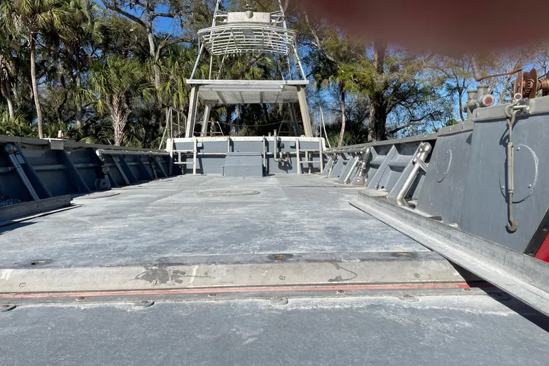 Asi Tender Yacht Photos Pics 1987 Commercial Buoy Tender deck with metal structures, surrounded by trees and blue sky.
