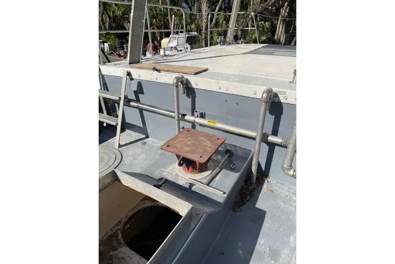 Asi Tender Yacht Photos Pics 1987 Commercial Buoy Tender deck with railing and open hatch, surrounded by trees.