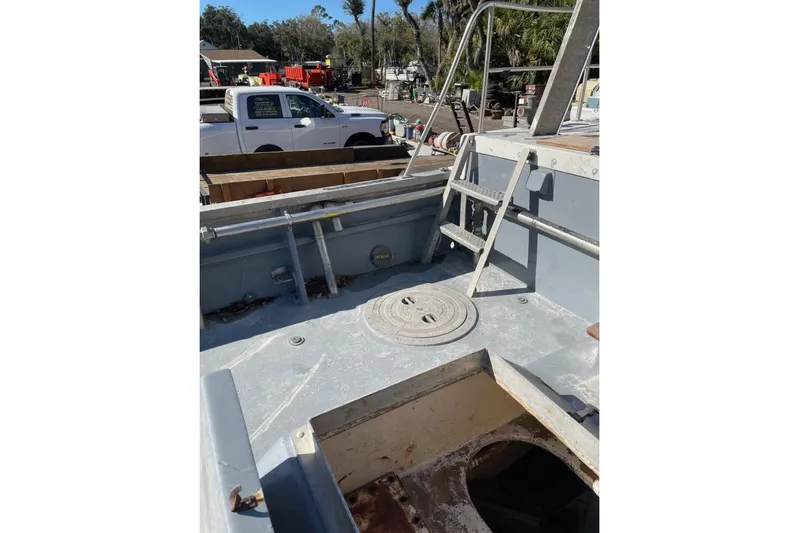 Asi Tender Yacht Photos Pics 1987 Commercial Buoy Tender deck with ladder, surrounded by equipment and vehicles.