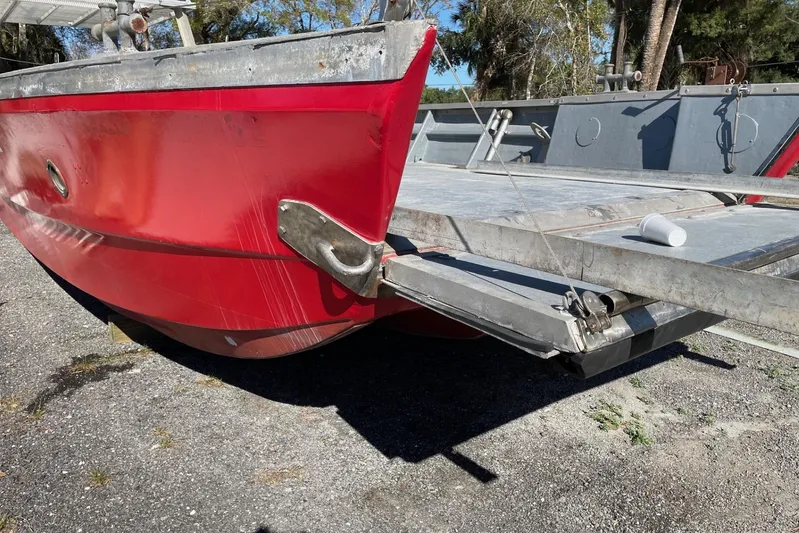 Asi Tender Yacht Photos Pics Red 1987 commercial buoy tender with metal deck, parked on gravel.