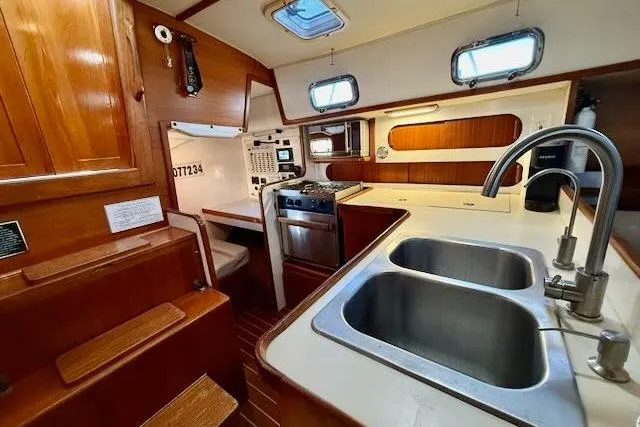 Windfall Yacht Photos Pics 1999 Caliber 40LRC yacht interior with kitchen, dual sinks, and wooden cabinetry.