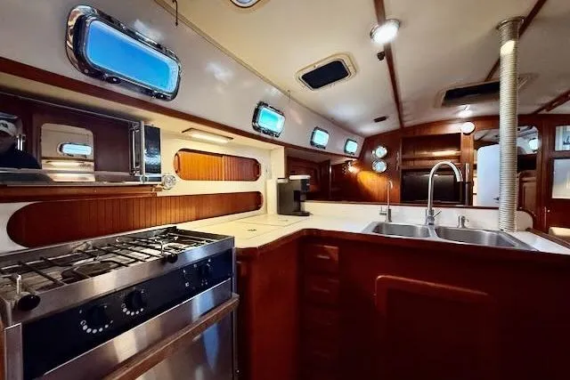 Windfall Yacht Photos Pics Interior of 1999 Caliber 40LRC yacht kitchen with stove, sink, and wooden cabinetry.