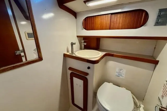 Windfall Yacht Photos Pics 1999 Caliber 40LRC yacht bathroom with sink, toilet, and wooden accents.