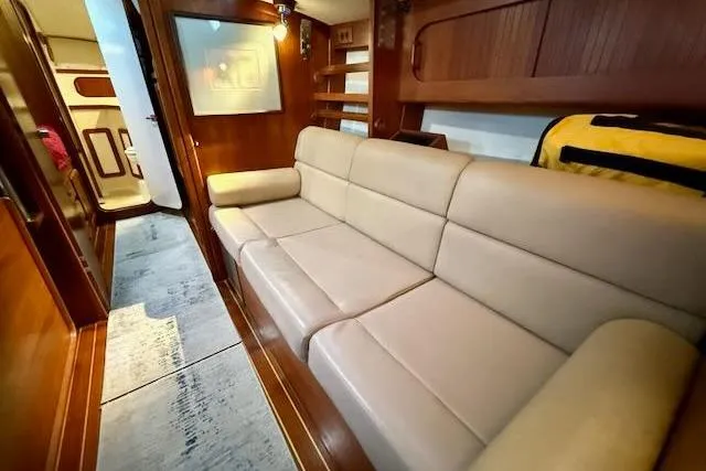 Windfall Yacht Photos Pics Interior of 1999 Caliber 40LRC yacht with beige leather sofa and wooden accents.