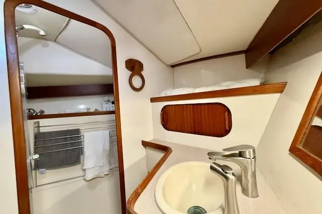 Windfall Yacht Photos Pics 1999 Caliber 40LRC yacht bathroom with sink, mirror, and wooden accents.