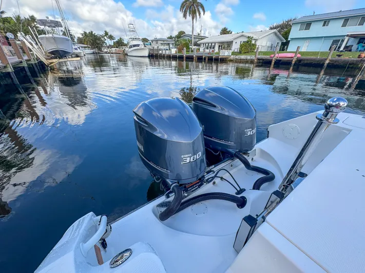  Yacht Photos Pics 2013 Edgewater 318CC boat with twin 300 horsepower engines docked in a serene marina.