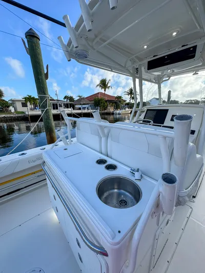  Yacht Photos Pics 2013 Edgewater 318CC boat interior with sink and rod holders, docked by waterfront homes.