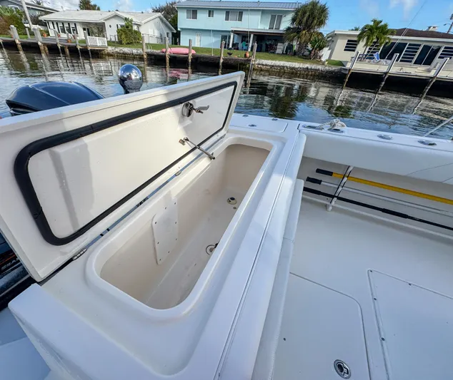  Yacht Photos Pics Open storage compartment on 2013 Edgewater 318CC boat by a waterfront dock.