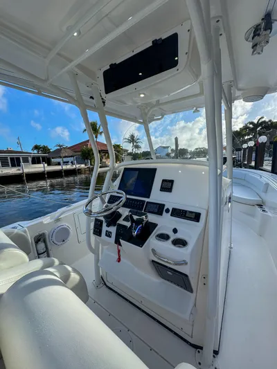  Yacht Photos Pics 2013 Edgewater 318CC boat cockpit with steering wheel, control panel, and seating, docked by waterfront.