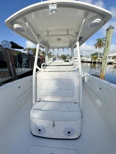  Yacht Photos Pics 2013 Edgewater 318CC boat interior with seating, docked by palm trees.