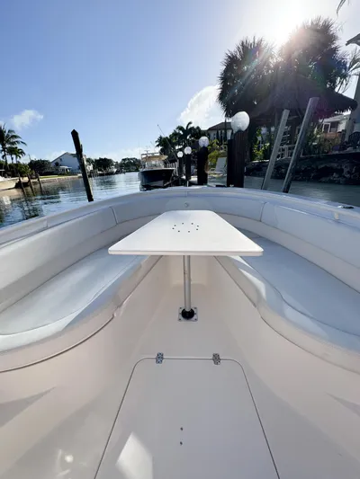  Yacht Photos Pics 2013 Edgewater 318CC boat interior with seating and table, docked in a sunny waterfront setting.