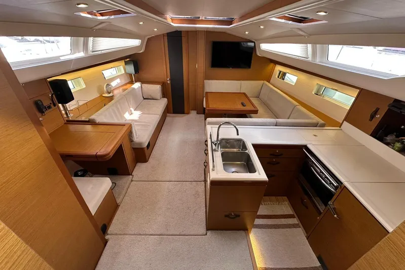  Yacht Photos Pics Luxurious interior of 2019 Jeanneau 51 yacht with modern kitchen and seating area.