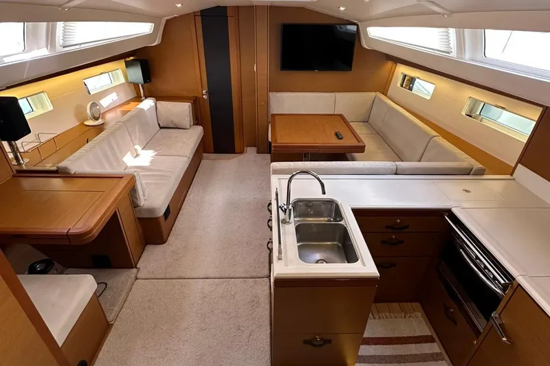  Yacht Photos Pics Luxurious interior of a 2019 Jeanneau 51 yacht with modern kitchen and seating area.
