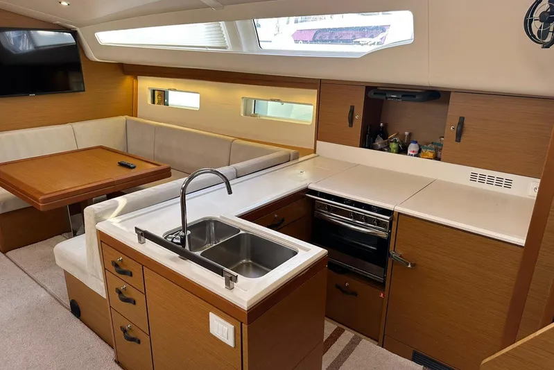  Yacht Photos Pics Luxurious interior of 2019 Jeanneau 51 yacht with modern kitchen and dining area.
