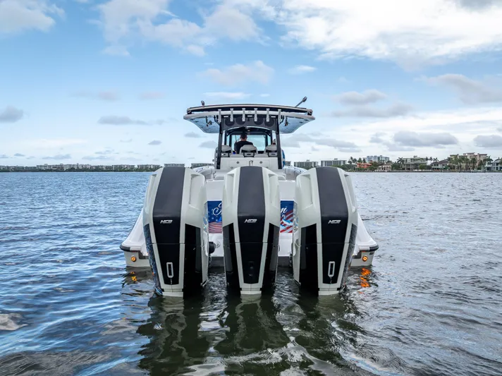 Seakeeper Equipped Yacht Photos Pics 2024 HCB 42 Lujo boat with triple outboard engines on a calm waterway.