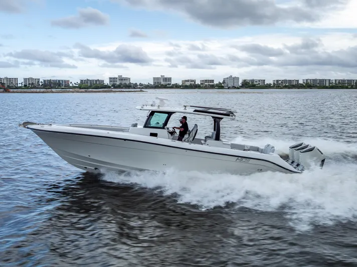 Seakeeper Equipped Yacht Photos Pics 2024 HCB 42 Lujo boat cruising on water with cityscape background.