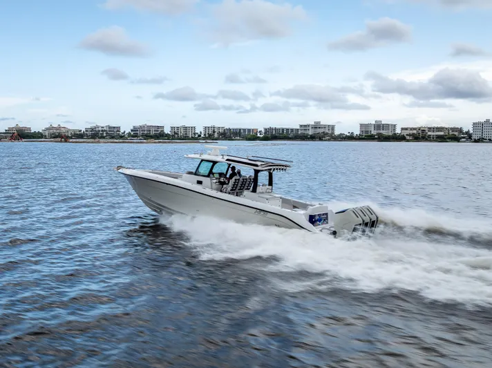 Seakeeper Equipped Yacht Photos Pics 2024 HCB 42 Lujo boat cruising on water with cityscape background.