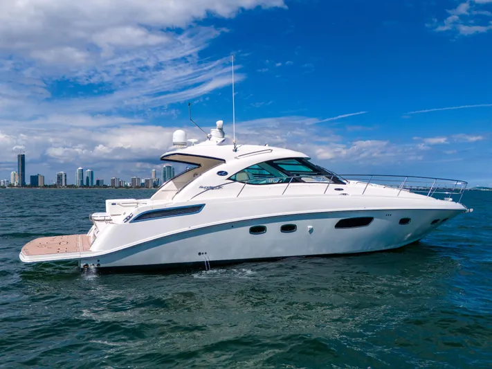  Yacht Photos Pics 2011 Sea Ray 470 Sundancer yacht cruising on open water with city skyline backdrop.