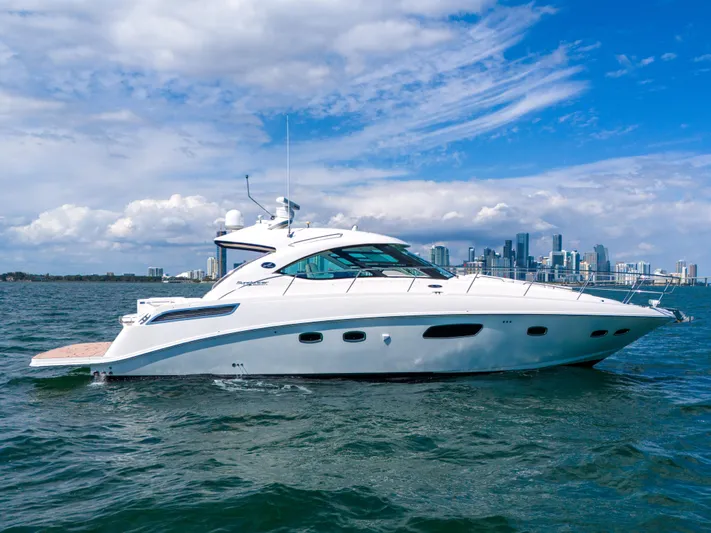  Yacht Photos Pics 2011 Sea Ray 470 Sundancer yacht cruising on open water with city skyline backdrop.