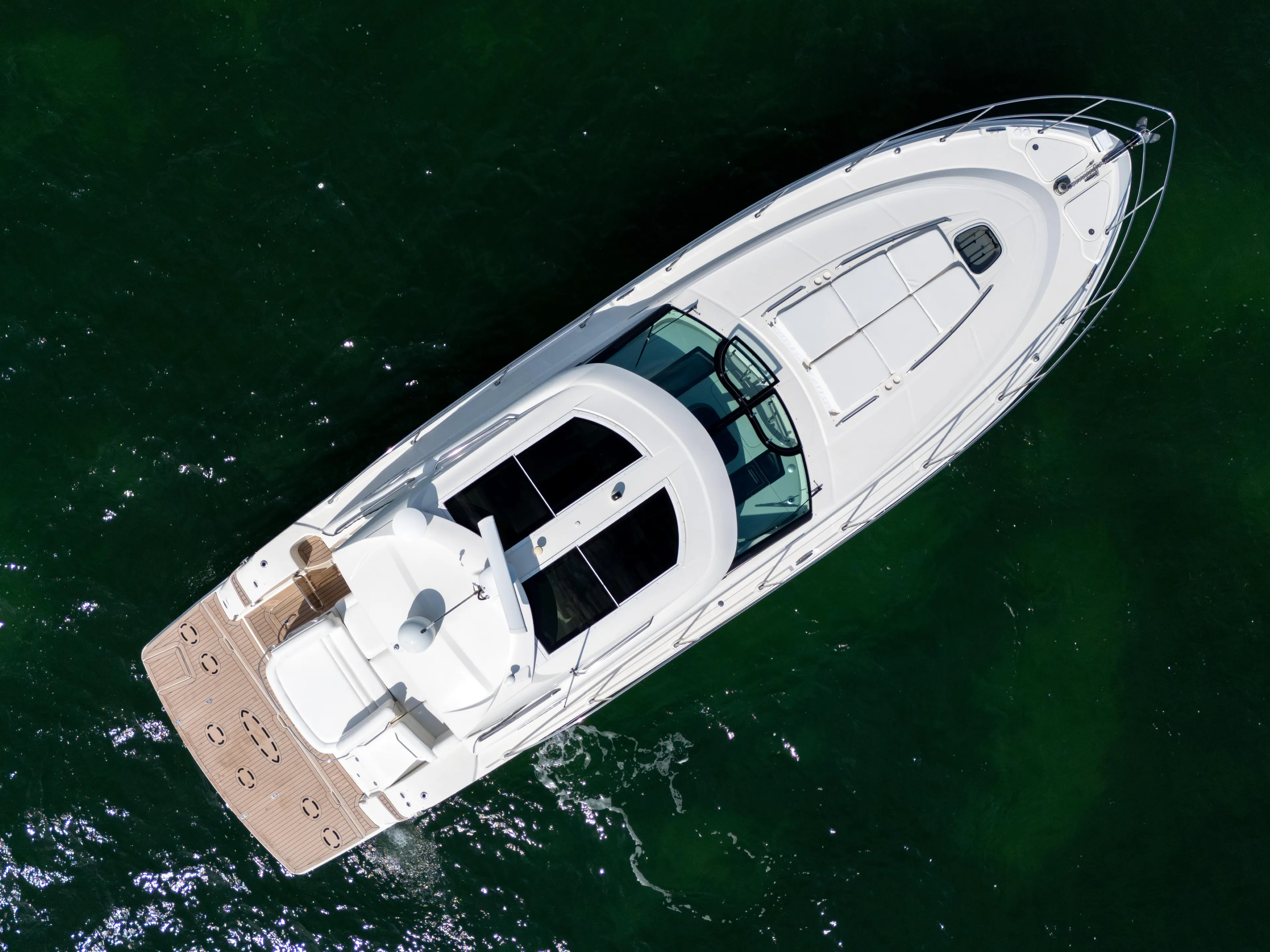  Yacht Photos Pics Overhead view of 2011 Sea Ray 470 Sundancer yacht on green water.