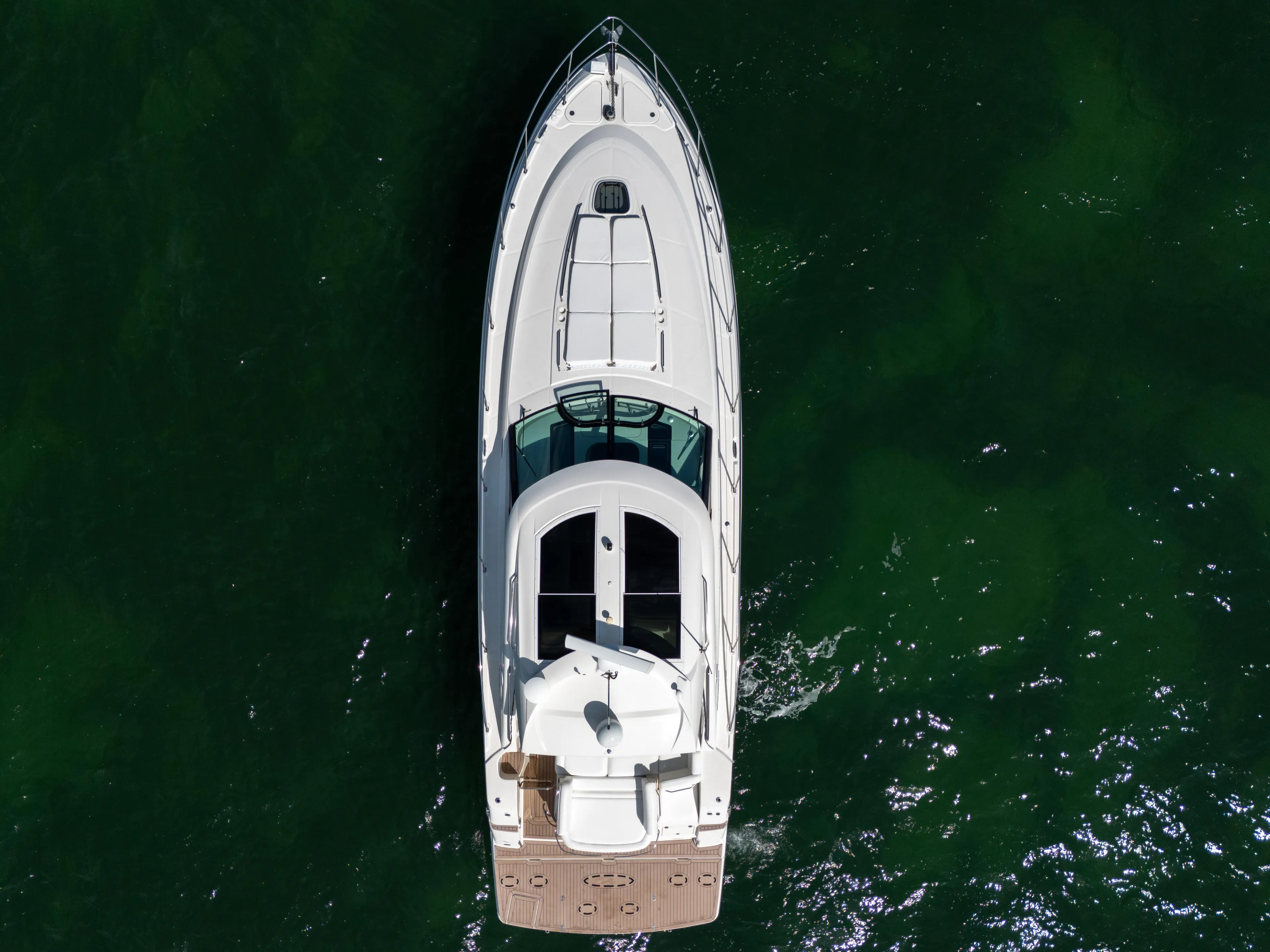  Yacht Photos Pics Aerial view of 2011 Sea Ray 470 Sundancer yacht on green water.