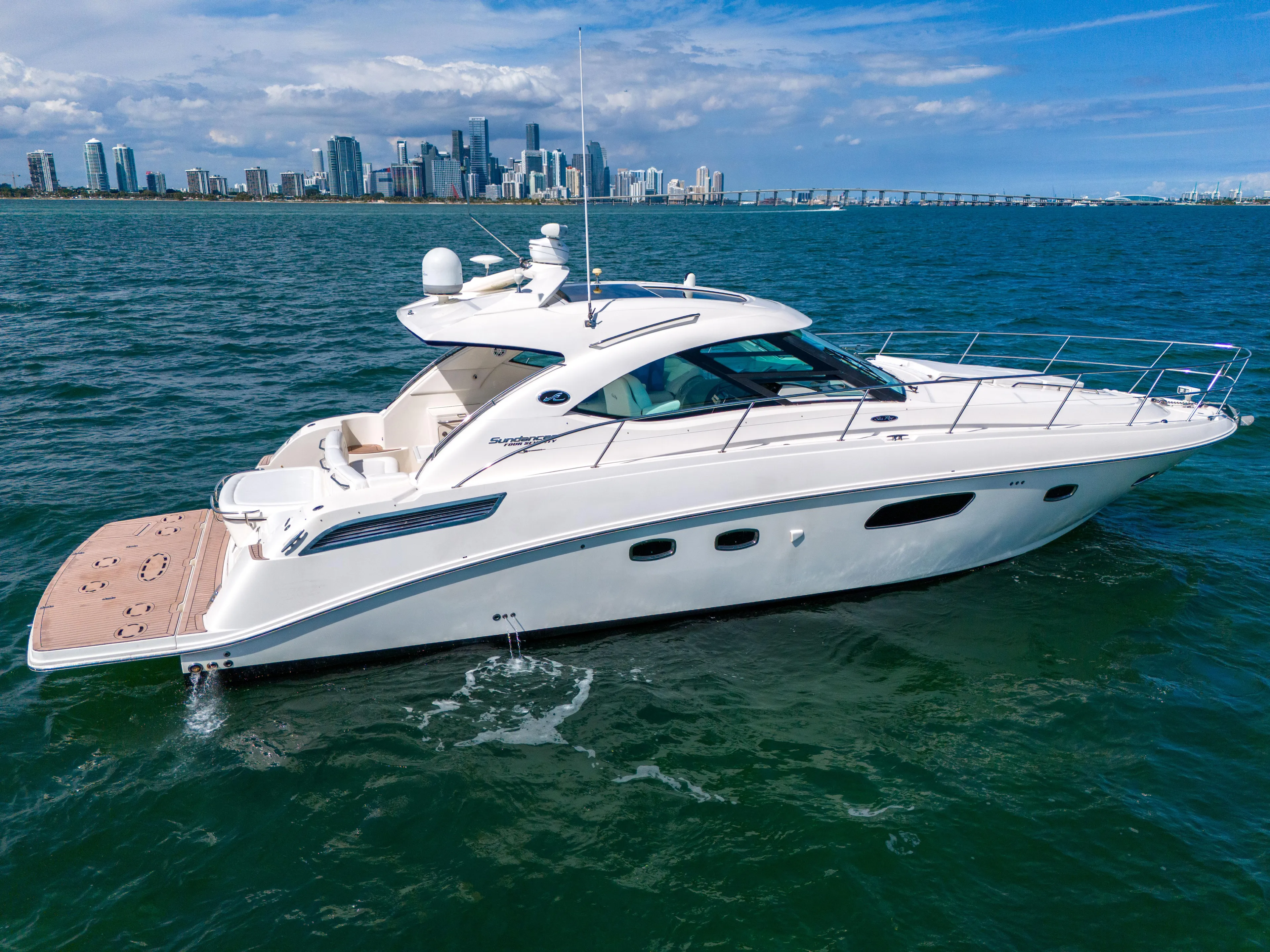  Yacht Photos Pics 2011 Sea Ray 470 Sundancer yacht cruising near city skyline on a sunny day.