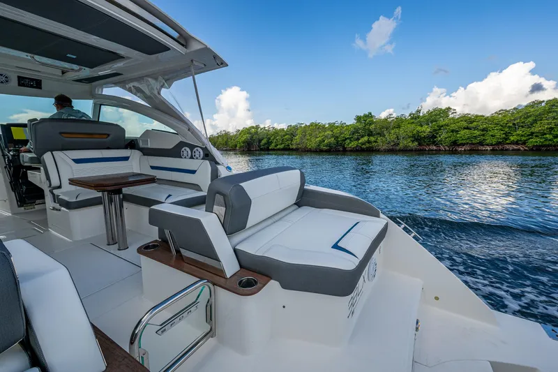  Yacht Photos Pics 2021 Tiara Yachts 38 LX cruising on a serene waterway with lush greenery.