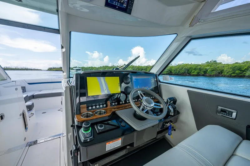  Yacht Photos Pics Interior view of 2021 Tiara Yachts 38 LX helm with navigation screens and steering wheel.