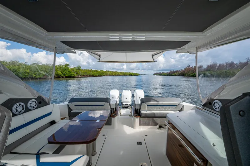  Yacht Photos Pics 2021 Tiara Yachts 38 LX interior with scenic waterway view, featuring luxurious seating and table.