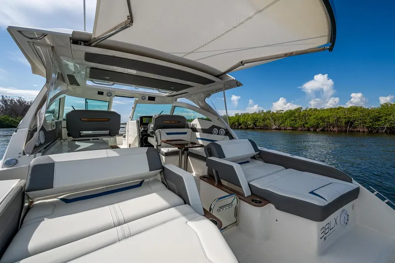  Yacht Photos Pics Luxurious 2021 Tiara Yachts 38 LX with spacious seating and canopy on a serene waterway.