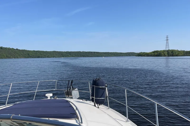 100% Fresh Water Yacht Photos Pics 2003 Sea Ray 420 Sundancer cruising on a serene lake under a clear blue sky.