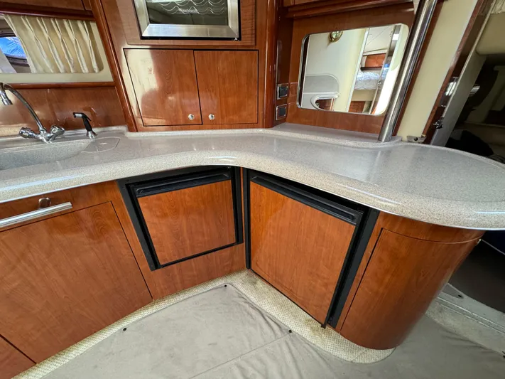 100% Fresh Water Yacht Photos Pics 2003 Sea Ray 420 Sundancer kitchen with wood cabinetry and modern appliances.