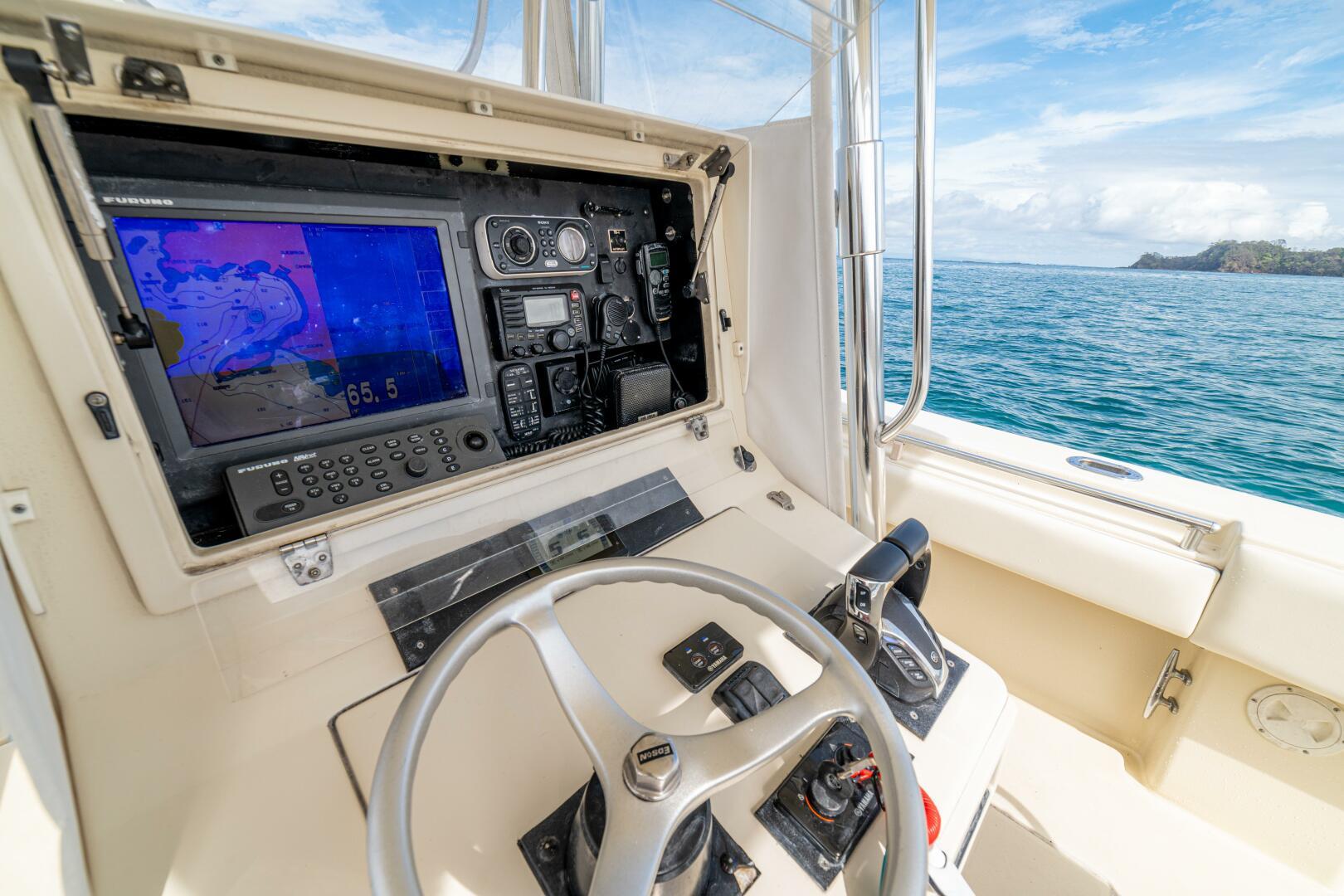 2007 Contender 33 boat cockpit with navigation system, steering wheel, and ocean view.