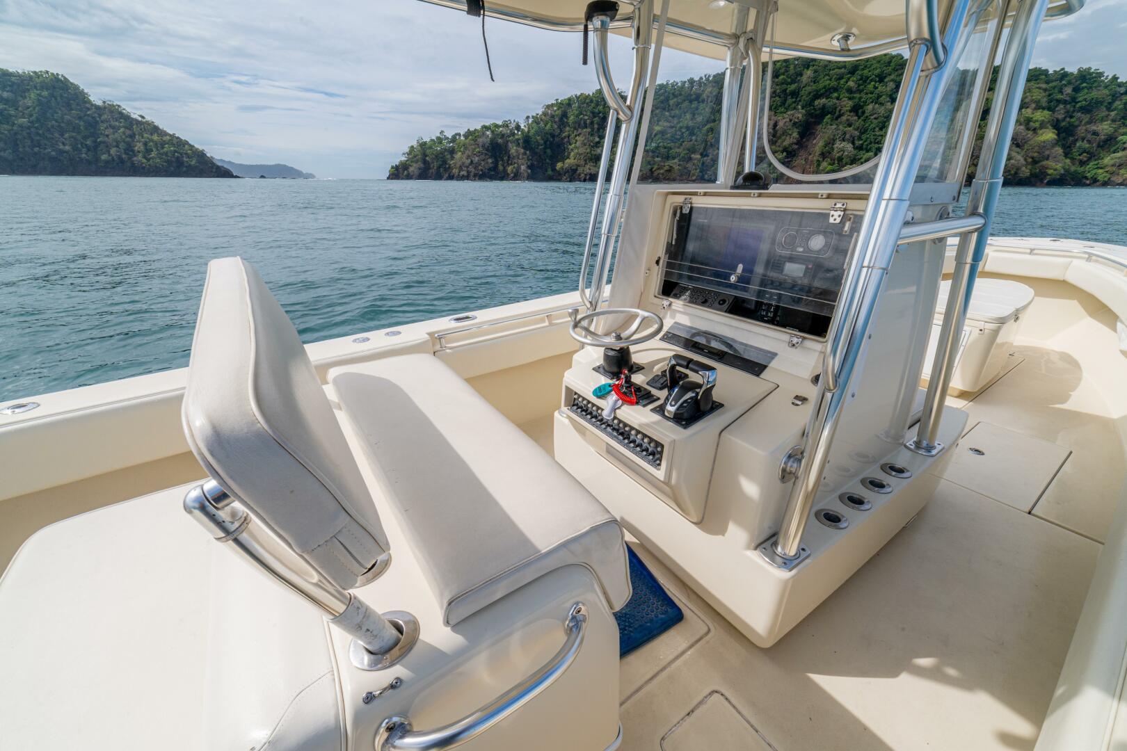 2007 Contender 33 boat interior with helm, ocean view, and lush green islands.