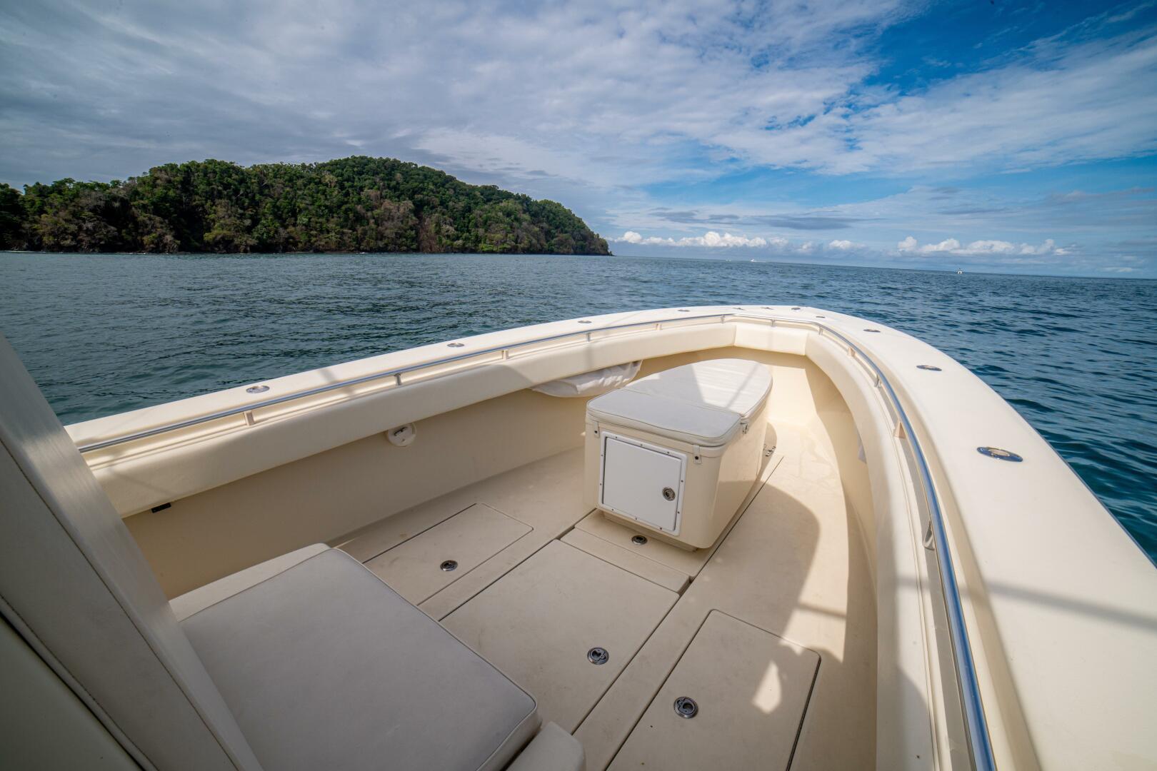 2007 Contender 33 boat on open sea with island view under blue sky.