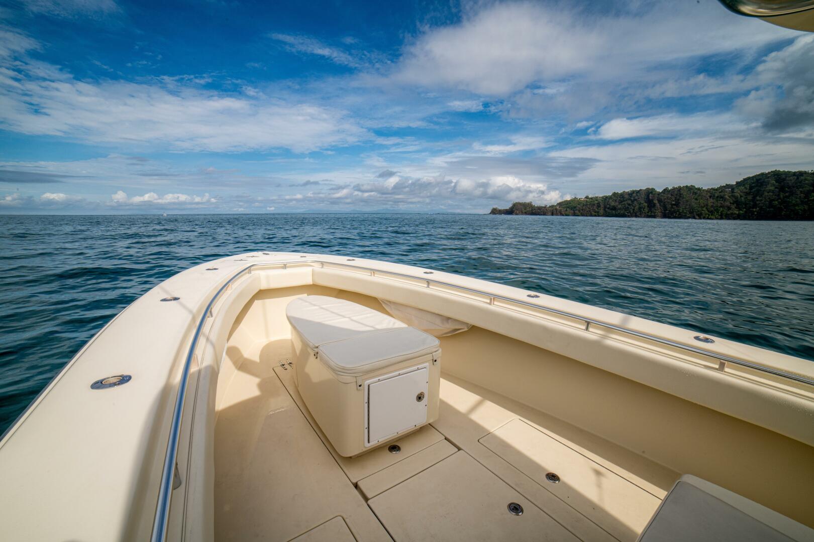 2007 Contender 33 boat on open sea with clear skies and distant shoreline.