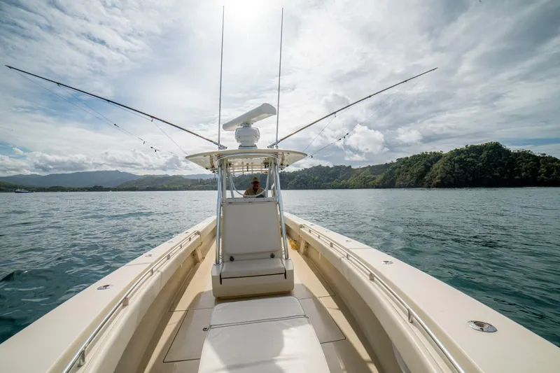 D Flawless Yacht Photos Pics 2007 Contender 33 boat cruising on a scenic lake under a cloudy sky.