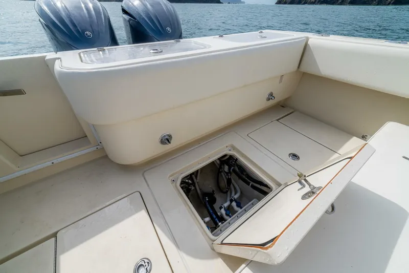 D Flawless Yacht Photos Pics 2007 Contender 33 boat deck with open hatch, revealing engine compartment.