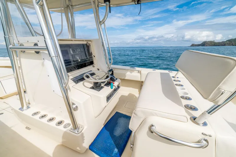 D Flawless Yacht Photos Pics 2007 Contender 33 boat interior with steering console, ocean view, and clear sky.