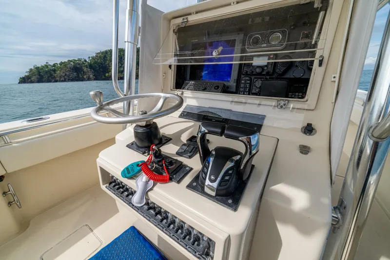 D Flawless Yacht Photos Pics 2007 Contender 33 boat helm with steering wheel, controls, and navigation equipment.